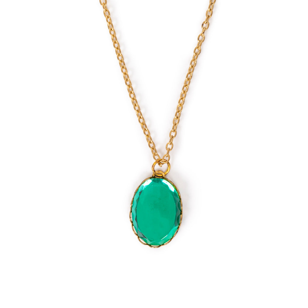 Green glass stone in gold backing, and hanging on gold chain. Solid white background.