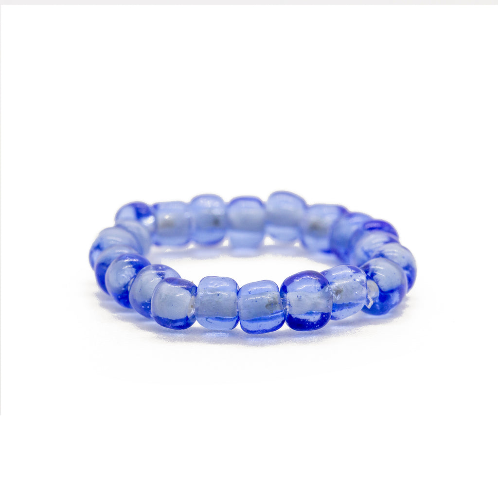 Blue beaded ring on solid white background.