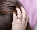 Detailed angle view of cubic zirconium ring on hand, hold hair up