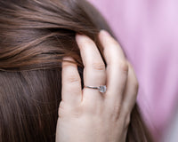 Detailed angle view of cubic zirconium ring on hand, hold hair up