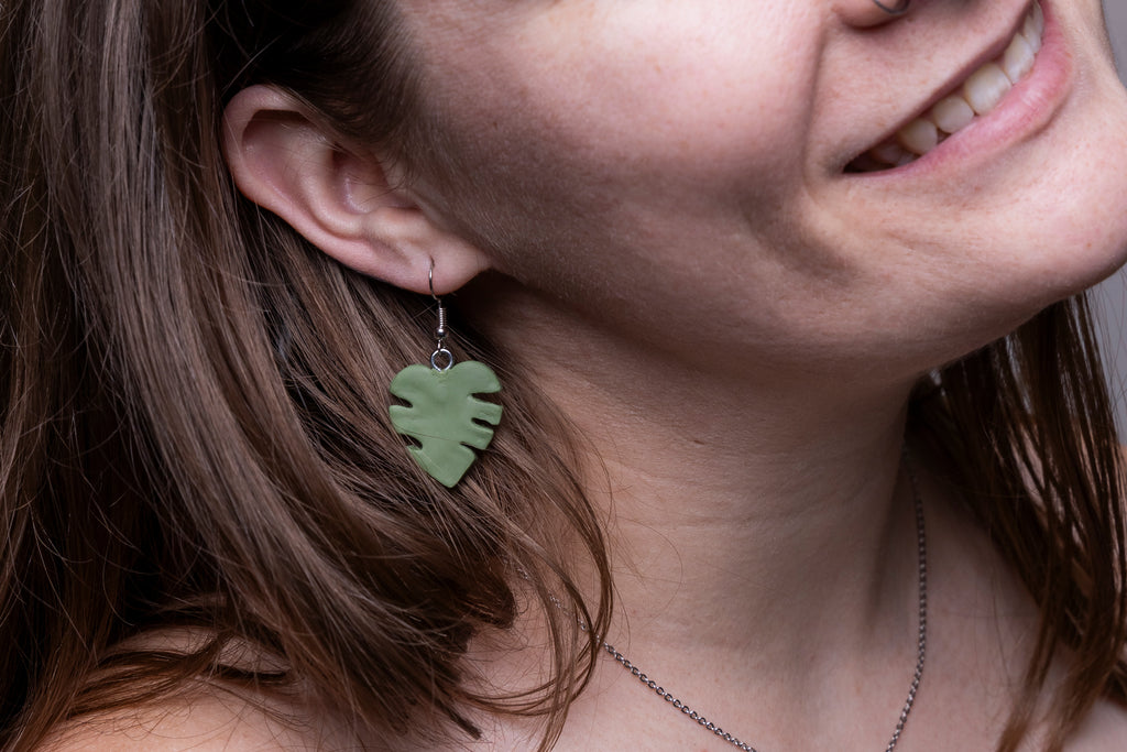 Up close view of monster leaf earrings on model's ear