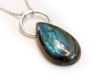 Labradorite pendant laying angled on solid white background.