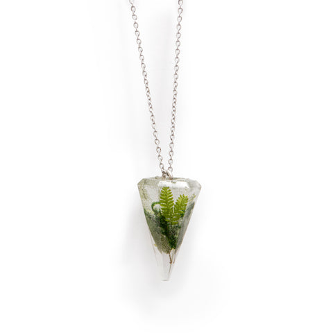 Clear resin pointed pendant filled with moss and other greenery, hanging on a stainless steel chain