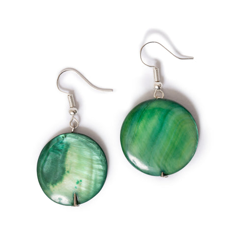 Green round earrings with silver hooks laying on solid white background.
