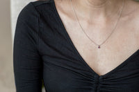 Ruby necklace shown on model's neck for size reference.