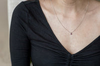 Ruby necklace shown on model's neck for size reference.