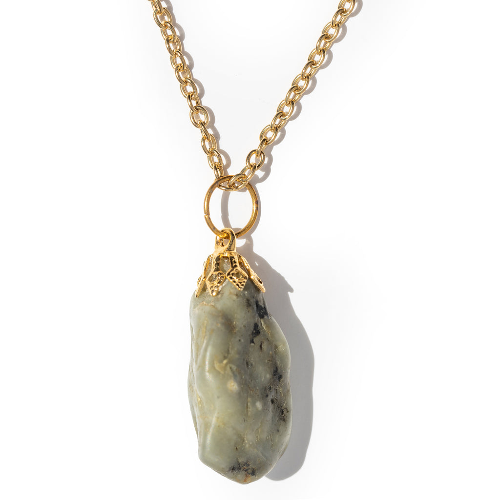 Green / Gray mostly tumbled stone, hanging on gold bail and chain, laying on a solid white background.