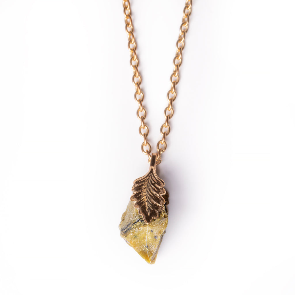 Serpentine pendant hanging on solid white background.