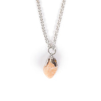 Smaller tumbled pink tone sodalite, hanging on imitation silver bail and chain. Image is on a solid white background.