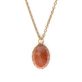 Goldstone in gold backing, and hanging on gold chain. Solid white background.