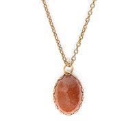 Goldstone in gold backing, and hanging on gold chain. Solid white background.