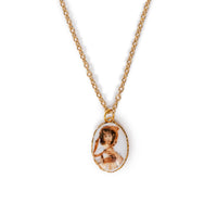 Vintage lady in gold backing, and hanging on gold chain. Solid white background.