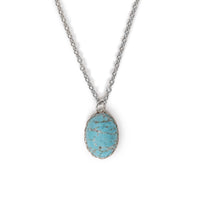 Imitation turquoise in silver backing, and hanging on silver chain. Solid white background.