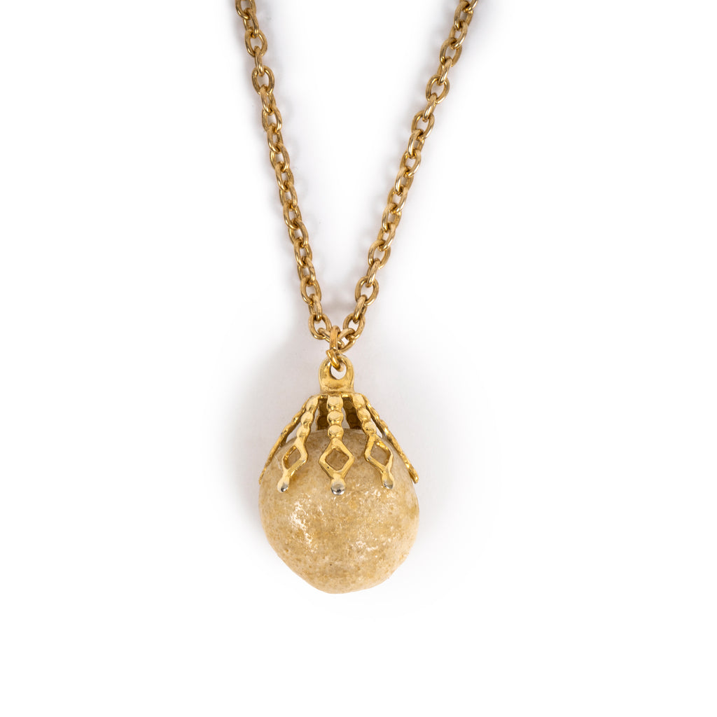Cute round cream stone in gold bail, hanging on gold chain. 