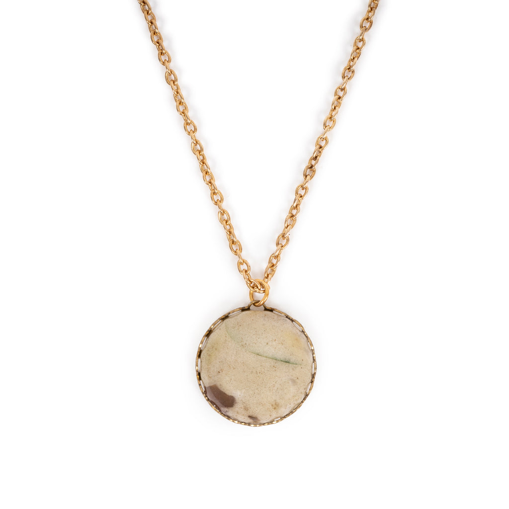 Agate round cab in gold backing, hanging on gold chain.