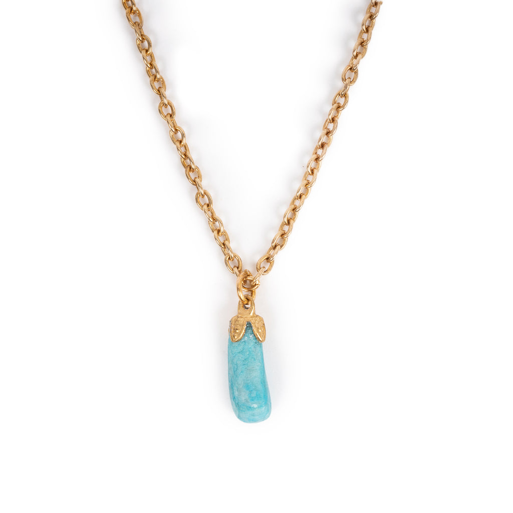 A small tumbled turquoise stone in gold tone bail on chain, sitting on solid white background.