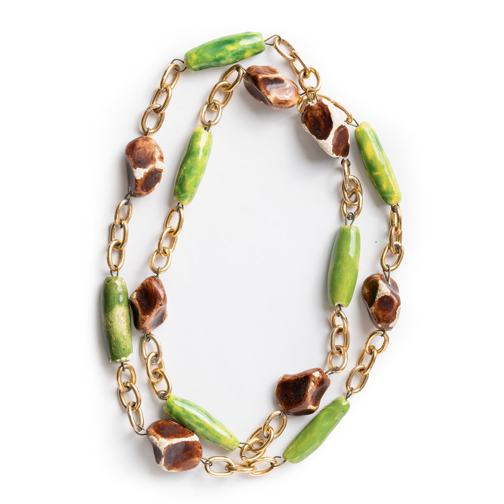 Chunky green and brown beaded and chain necklace overlay on itself, laying on a white background.