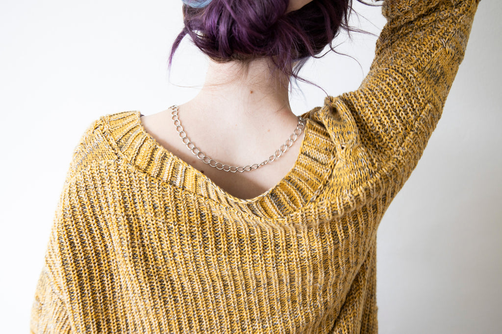 Model showing silver tone lariat necklace on the back of her neckline.