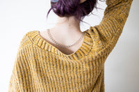 Model showing silver tone lariat necklace on the back of her neckline.