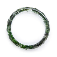 Overhead view of clear resin bangle bracelet with moss inside