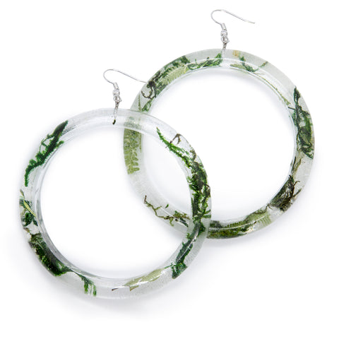 Resin hoops, filled with moss and leaves, laying on white background