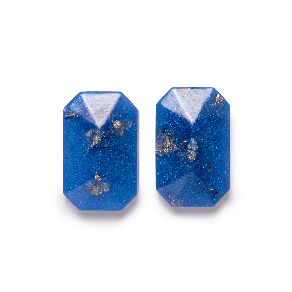 Blue glittery faceted rectangle with gold fleck inside, both facing forward. Image is on solid white background.