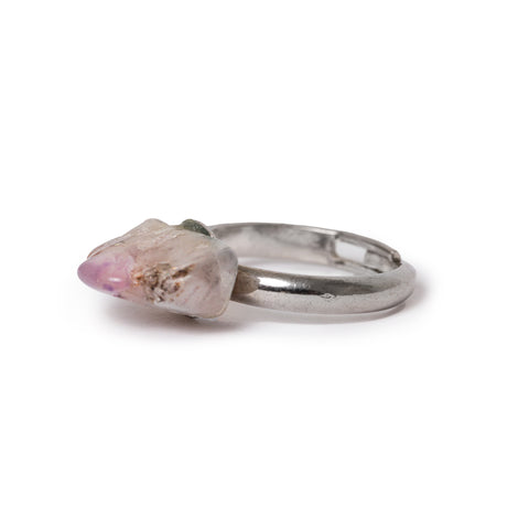 3/4 view of amethyst ring laying on solid white background. 