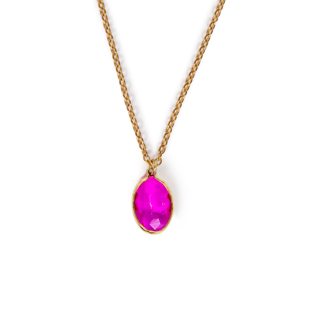 Pink faceted glass charm hanging on gold chain, on solid white background.