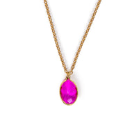 Pink faceted glass charm hanging on gold chain, on solid white background.