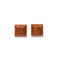 Gold glittery square earrings both facing forward. Image on solid white background.