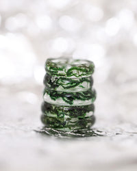 Various sizes of the moss resin ring stacked on each other. the background is a shimmery bokeh silver tone.