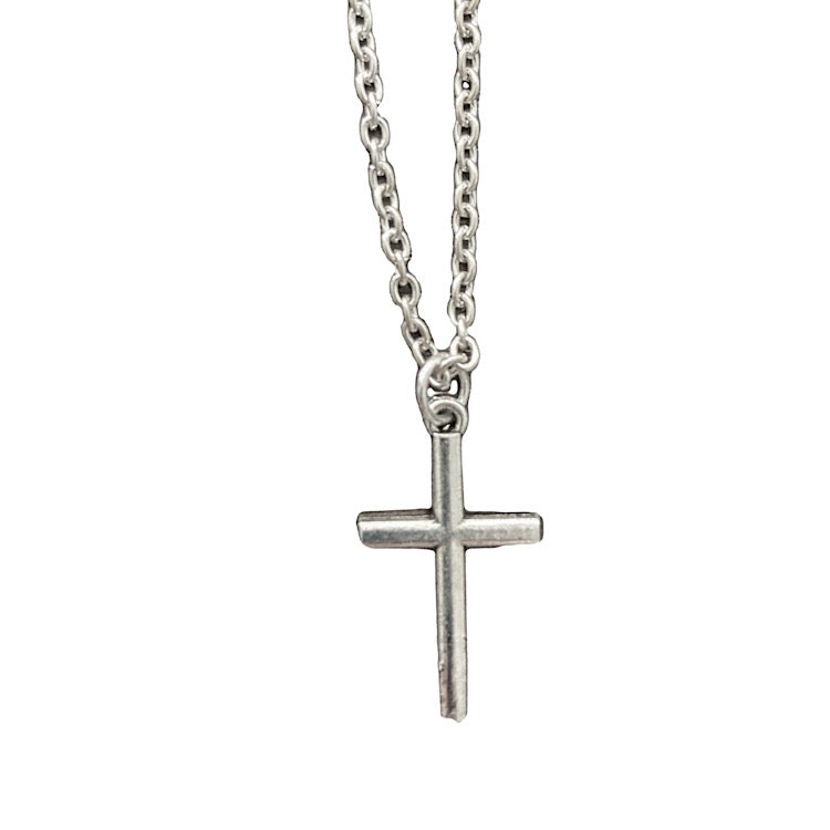 Small silver cross and chain on solid white background