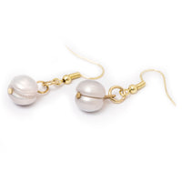 Pearl drop earrings laying flat on a solid white background.