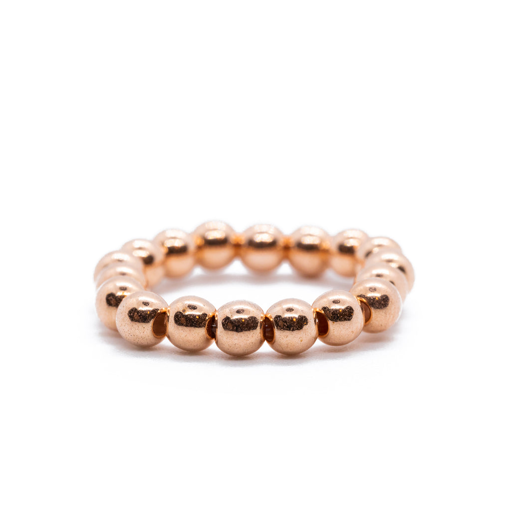 Rose tone beaded ring on solid white background.