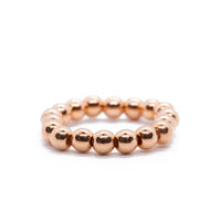 Rose tone beaded ring on solid white background.
