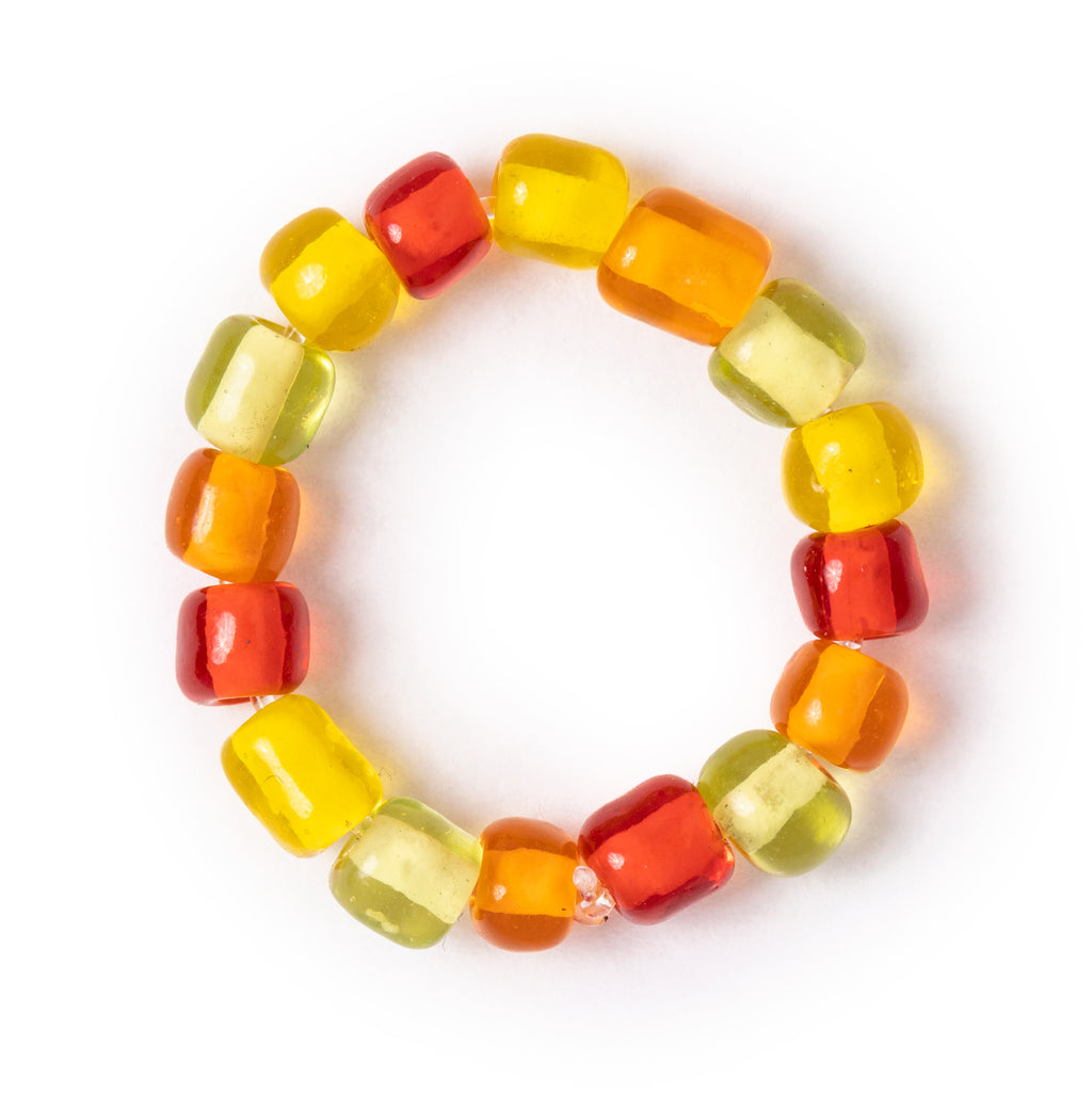 Bright ring, including red, orange, yellow, and green beads, on an overhead view, with solid white background.
